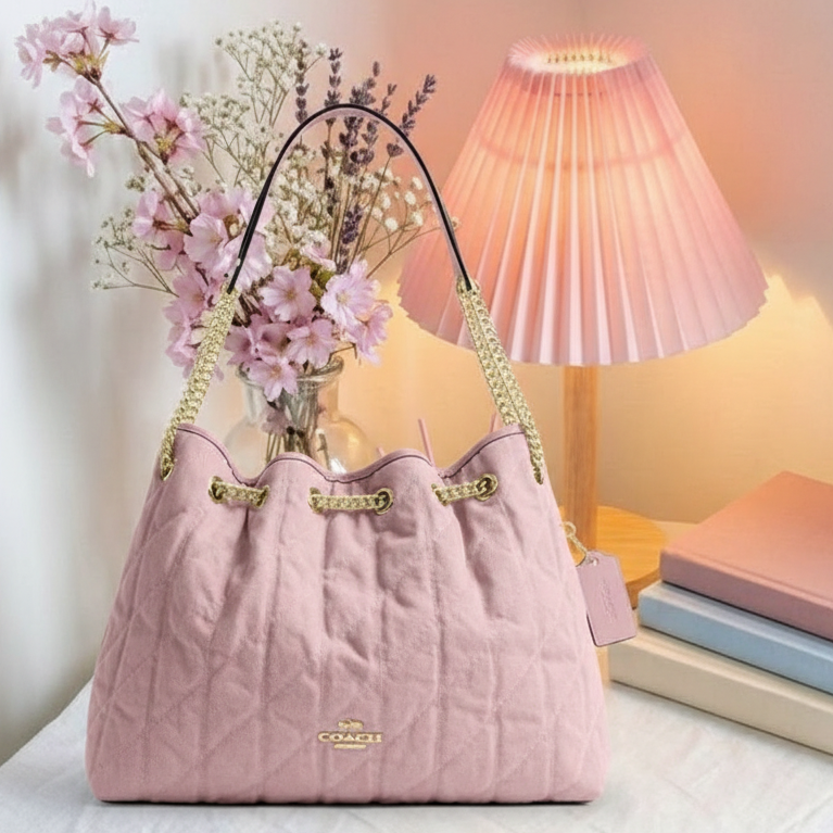 Coach pink quilted bag on cozy background