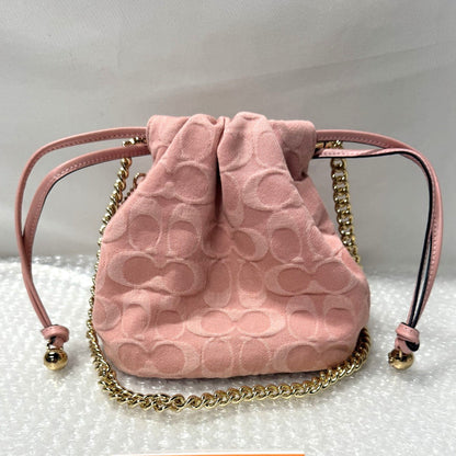 Pink textured handbag with gold chain and 'Fancy Tokyo Tokyo' card on a white background