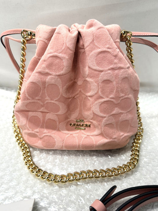 Pink drawstring bag with gold chain on a white background