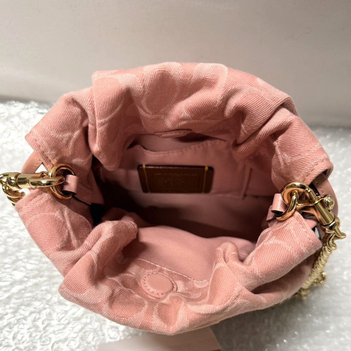 Pink velvet handbag with gold chain handle on a white background, featuring a 'Fancy Tokyo' tag.